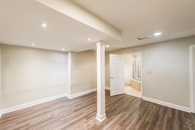 finished below grade area featuring recessed lighting, baseboards, and wood finished floors