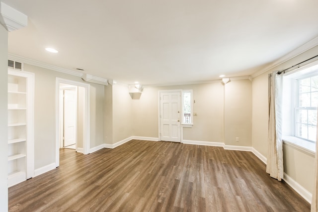 empty room with crown molding, hardwood / wood-style flooring, and built in shelves