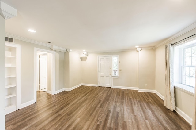 unfurnished room with visible vents, dark wood finished floors, and baseboards