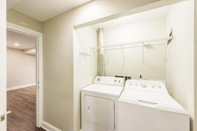 laundry room featuring washing machine and dryer, dark wood-style flooring, baseboards, and laundry area