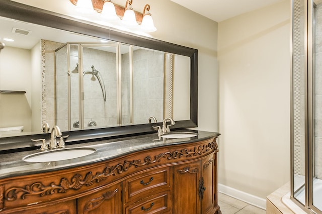 bathroom with visible vents, a sink, a shower stall, and tile patterned floors