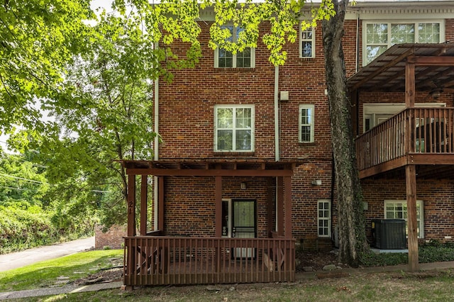 back of property with cooling unit and brick siding