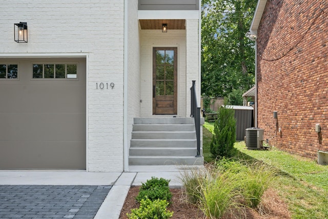 doorway to property with cooling unit and a garage