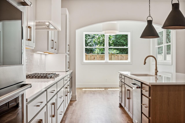 kitchen with white cabinetry, decorative light fixtures, and sink