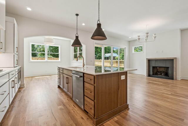 kitchen with a center island with sink, sink, light hardwood / wood-style floors, and white cabinetry