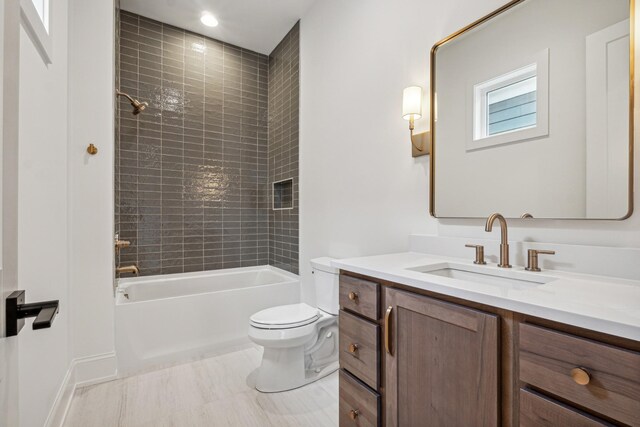 full bathroom featuring tile patterned floors, vanity, tiled shower / bath combo, and toilet