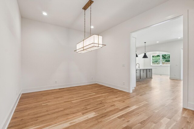 unfurnished dining area featuring sink and light hardwood / wood-style floors