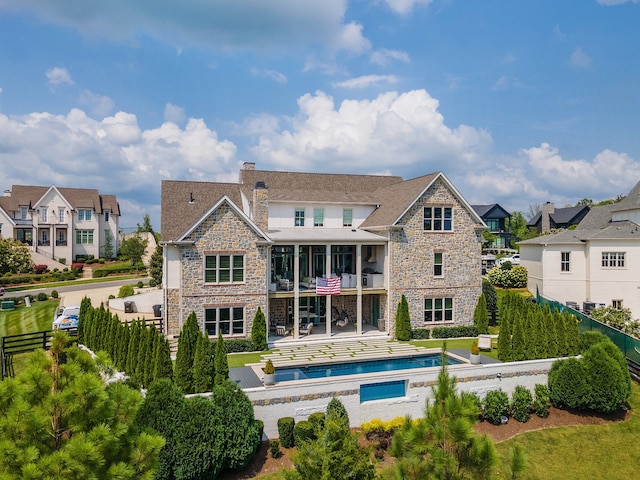 back of property with a balcony, a fenced in pool, and a patio