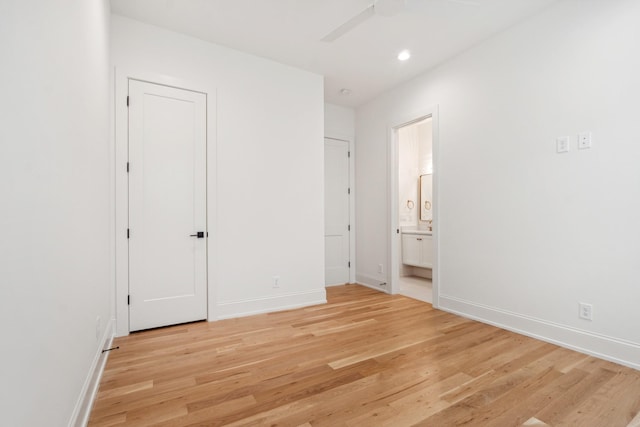 unfurnished bedroom featuring ensuite bathroom, ceiling fan, and light hardwood / wood-style floors