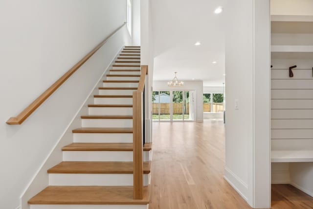 staircase featuring a notable chandelier and wood-type flooring