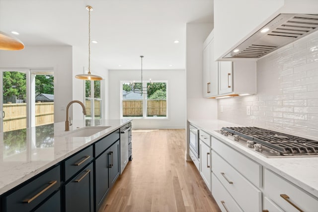 kitchen featuring pendant lighting, sink, appliances with stainless steel finishes, white cabinetry, and custom exhaust hood