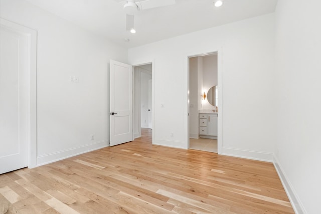 unfurnished bedroom with ensuite bath, light hardwood / wood-style floors, and ceiling fan