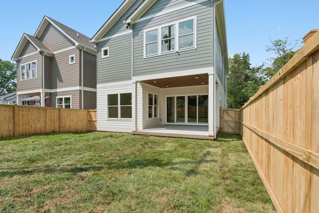 back of property with a yard and a patio area