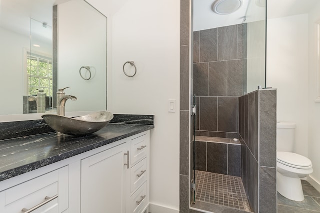 bathroom with toilet, an enclosed shower, vanity, and tile patterned flooring