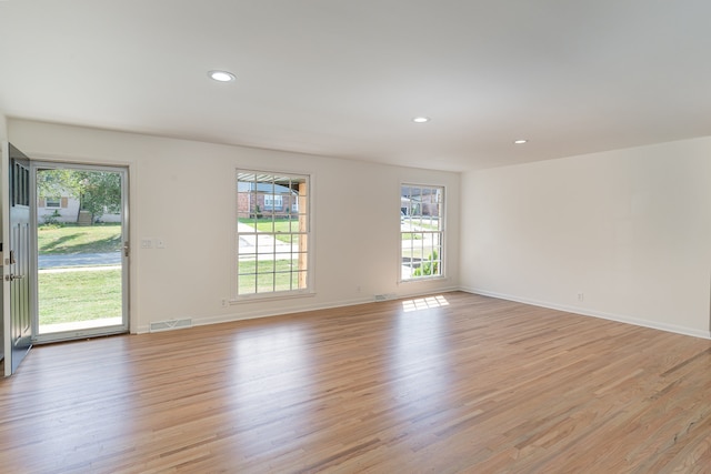 spare room with light wood-type flooring and a healthy amount of sunlight