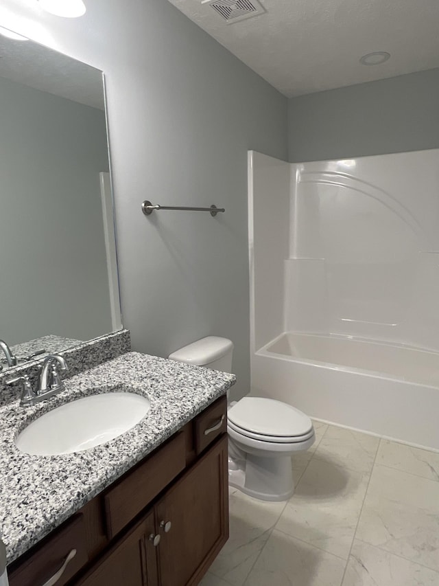 full bath with marble finish floor,  shower combination, vanity, and toilet