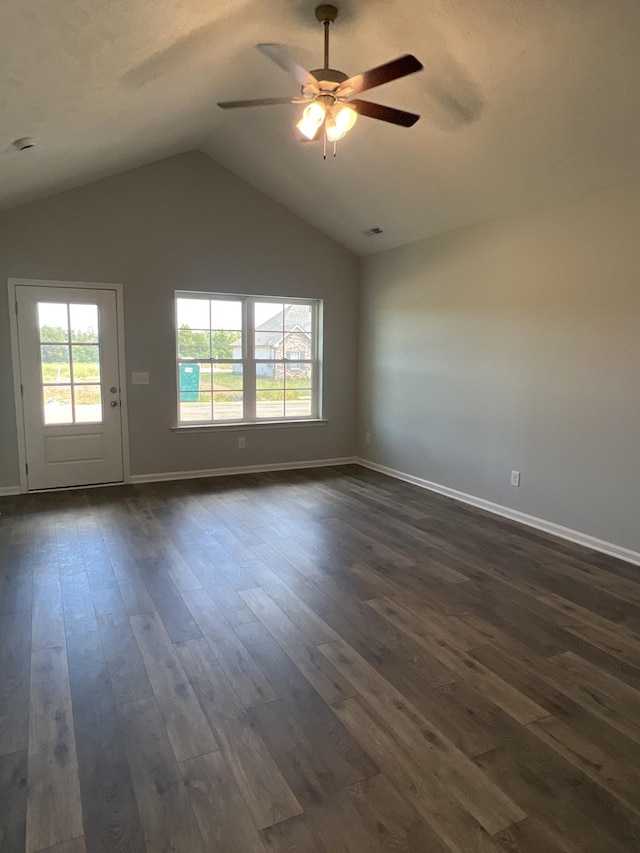 empty room with lofted ceiling, dark wood-type flooring, a ceiling fan, and baseboards