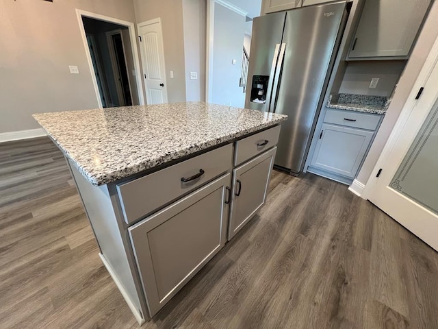 kitchen featuring a kitchen island, dark wood-style floors, stainless steel fridge, and gray cabinetry