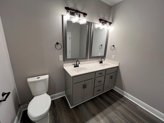 bathroom featuring wood finished floors, toilet, and a sink