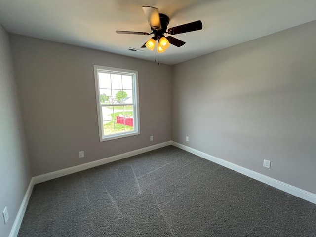 empty room with visible vents, baseboards, ceiling fan, and dark carpet