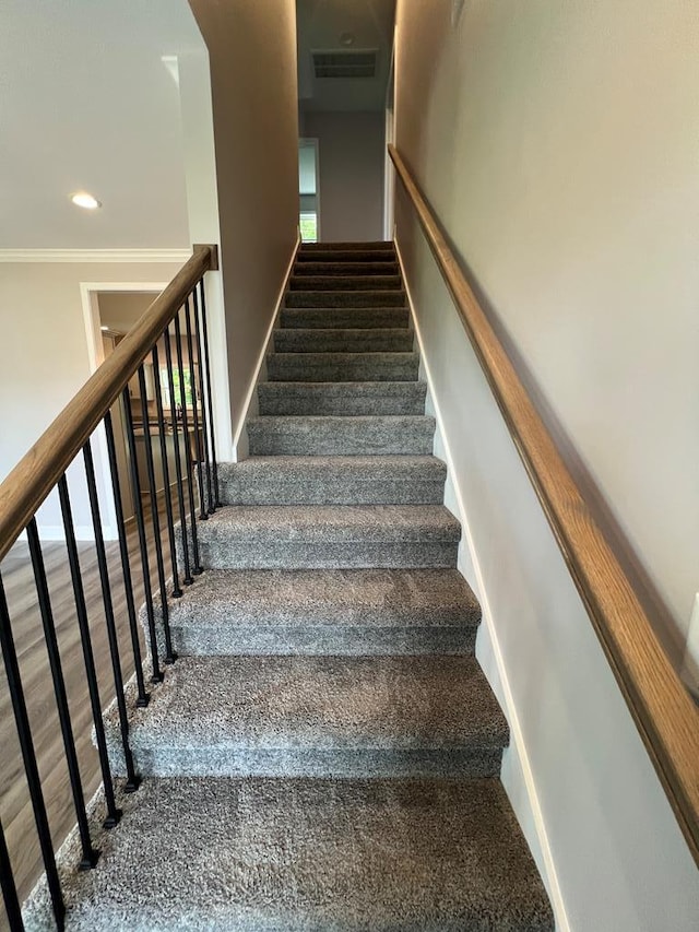 stairs featuring wood finished floors, baseboards, visible vents, recessed lighting, and crown molding