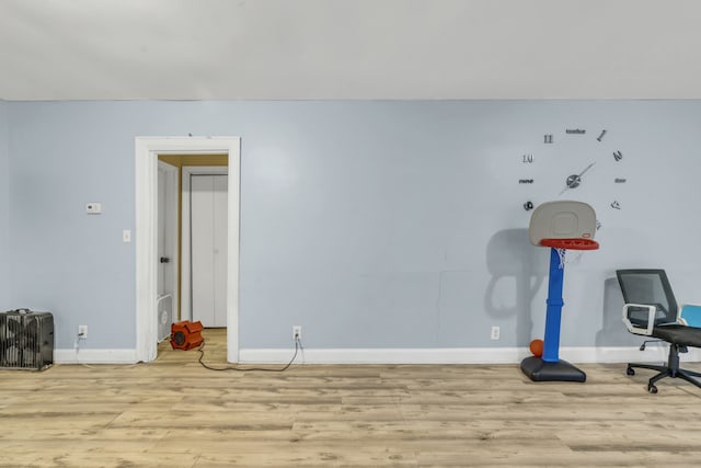 exercise room featuring light wood-type flooring