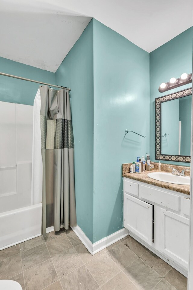 bathroom with tile patterned floors, shower / bathtub combination with curtain, and vanity