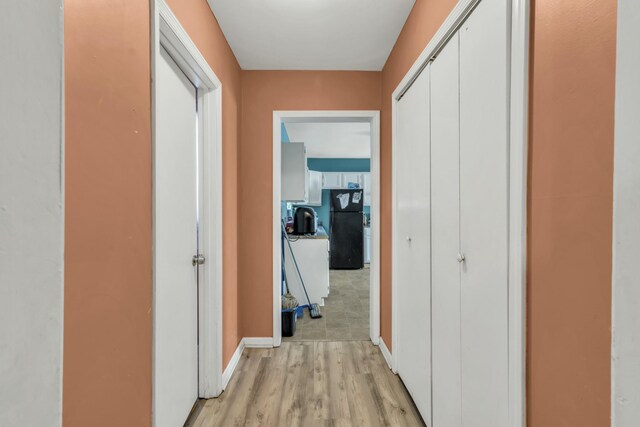 hallway with light hardwood / wood-style floors