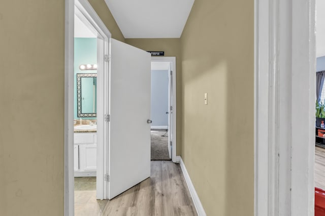 corridor featuring sink and light hardwood / wood-style flooring