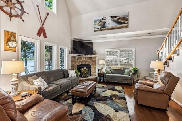 living area featuring a healthy amount of sunlight, wood-type flooring, and stairway