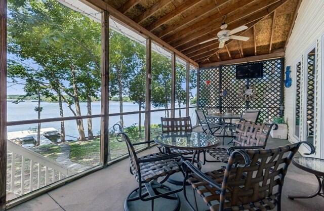 sunroom / solarium with ceiling fan, lofted ceiling, and a water view