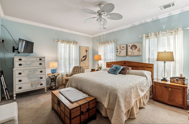 carpeted bedroom featuring ceiling fan and crown molding