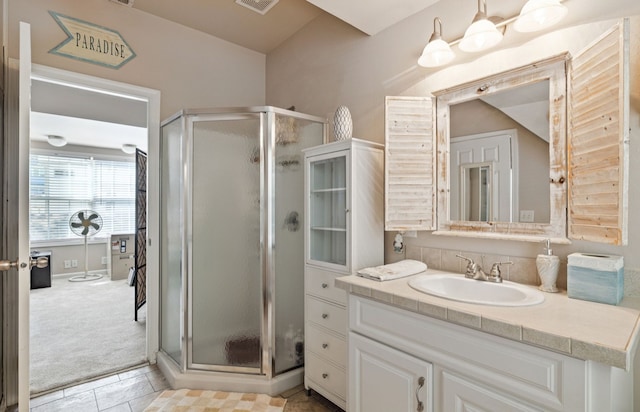 bathroom with tile patterned floors, vanity, and walk in shower