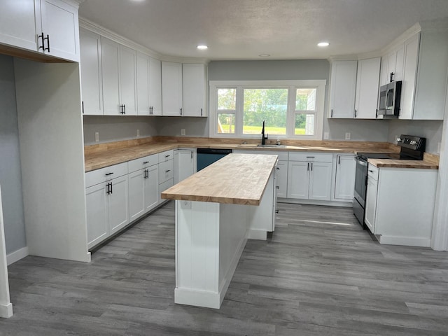 kitchen with white cabinetry, wood counters, appliances with stainless steel finishes, and sink