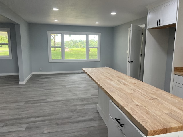 kitchen featuring light wood-type flooring, a wealth of natural light, white cabinetry, and wooden counters