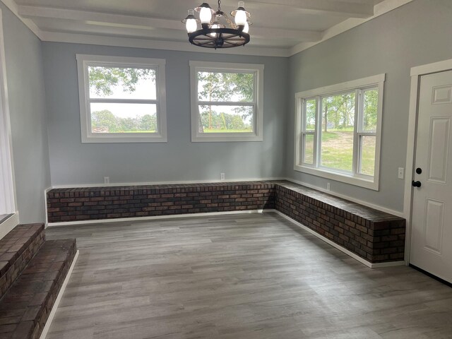 foyer with beamed ceiling, wood-type flooring, and a chandelier