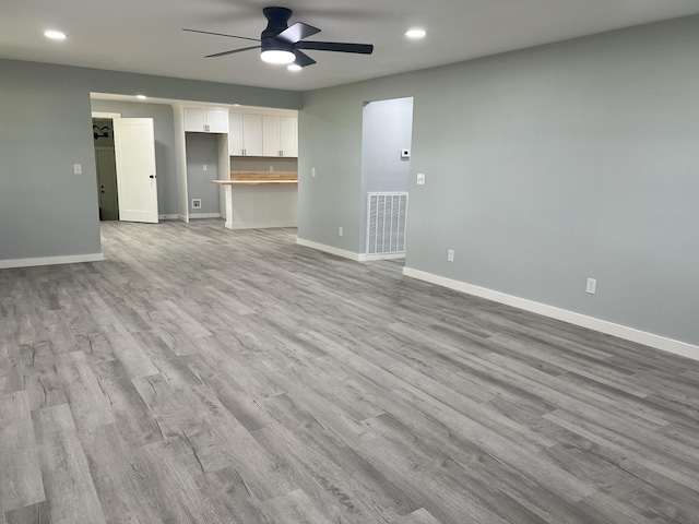 unfurnished living room with ceiling fan and light hardwood / wood-style flooring