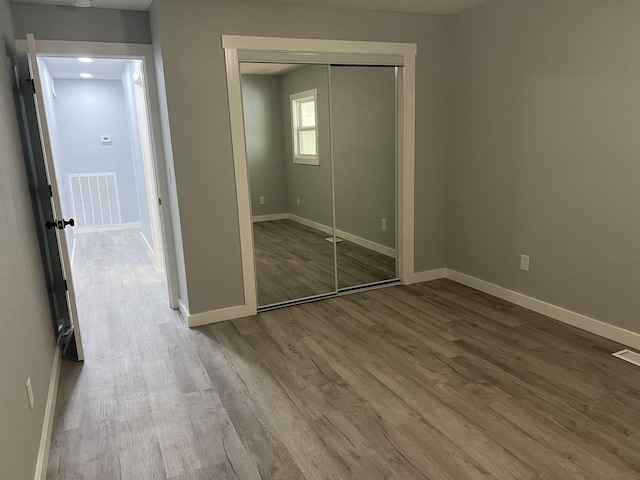 unfurnished bedroom with hardwood / wood-style floors and a closet