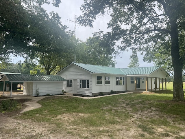 rear view of property with a carport and a lawn