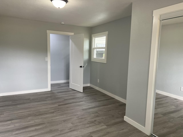 unfurnished room with dark wood-type flooring