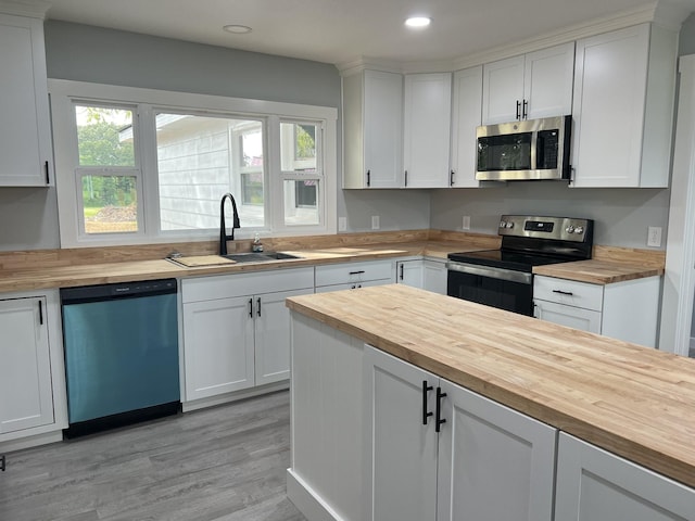 kitchen with white cabinetry, sink, wooden counters, and appliances with stainless steel finishes