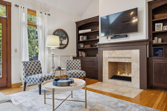 living room featuring a fireplace, vaulted ceiling, and light hardwood / wood-style floors