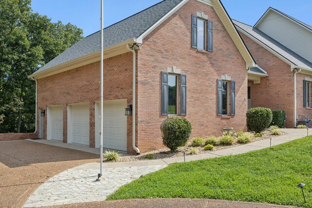 view of side of property with a garage and a lawn