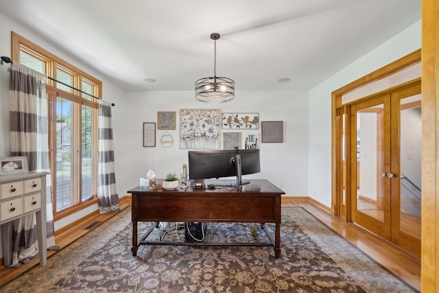 office space with french doors, wood-type flooring, and an inviting chandelier