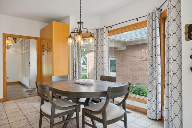 tiled dining room featuring an inviting chandelier