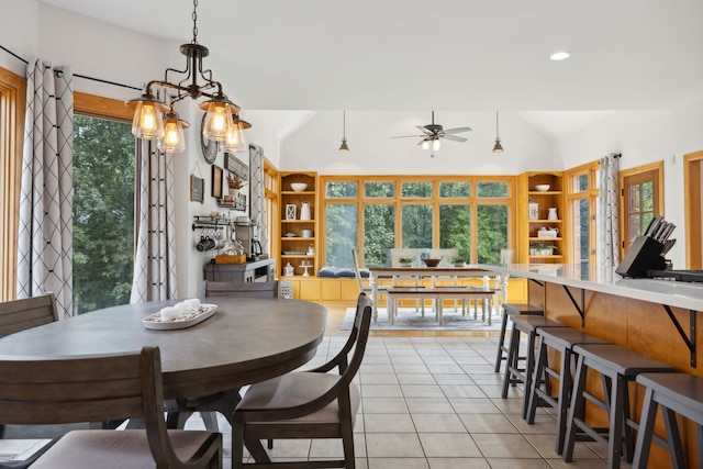 dining room featuring lofted ceiling, ceiling fan with notable chandelier, light tile patterned floors, and a wealth of natural light