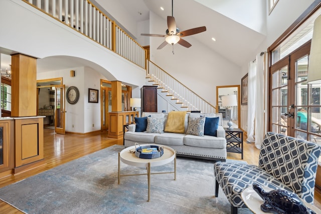 living room featuring ceiling fan, french doors, high vaulted ceiling, and hardwood / wood-style flooring