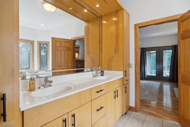 bathroom featuring double vanity, french doors, tile patterned flooring, and a healthy amount of sunlight