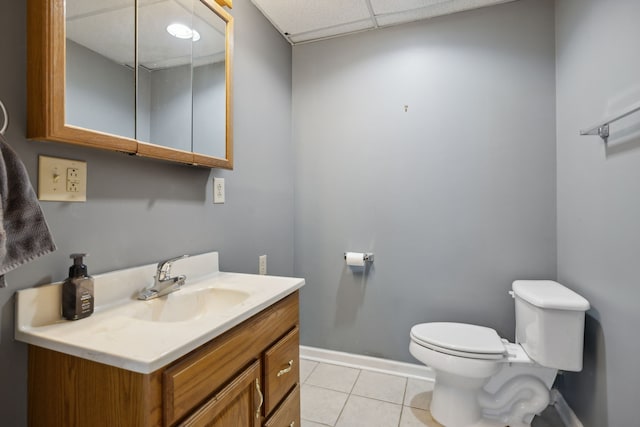 bathroom featuring vanity, a paneled ceiling, toilet, and tile patterned flooring