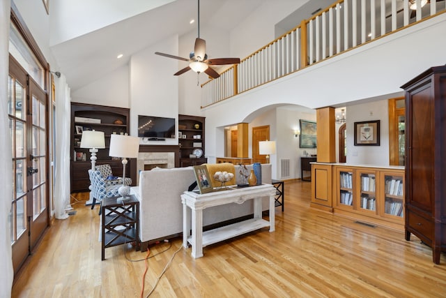 living room featuring high vaulted ceiling, a wealth of natural light, ceiling fan, and light hardwood / wood-style floors